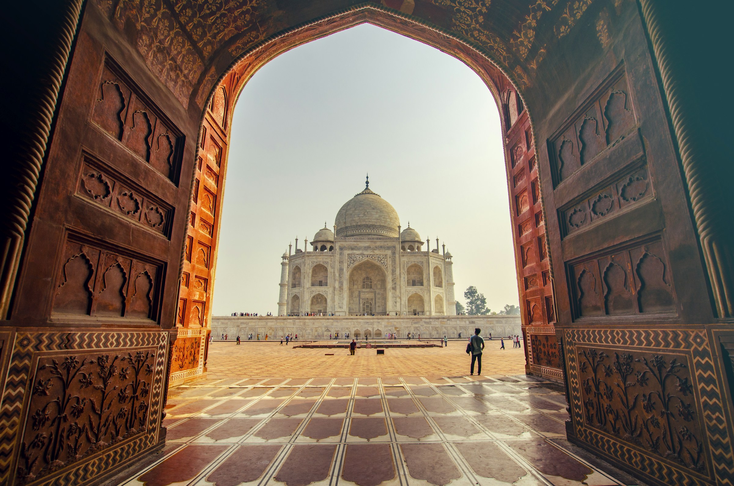 Taj Mahal framed in a sandstone gateway at golden hour